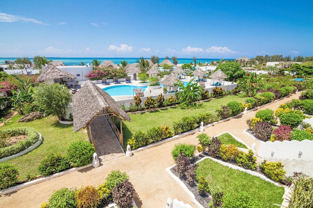 Una veduta aerea di un resort con piscina e capanne dal tetto in paglia che offre un'offerta viaggio SBS Viaggi experience.