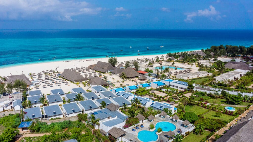Una spiaggia con edifici e piscina, protagonista dell'offerta viaggio a zanzibar alpitour.
