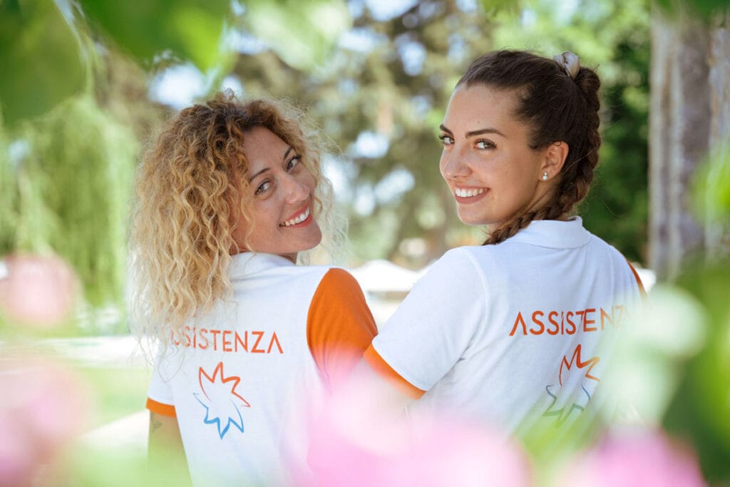 Due donne in maglietta arancione e bianca posano per una foto mentre si godono il loro viaggio a Zanzibar con Bravo Premium Kendwa Beach.