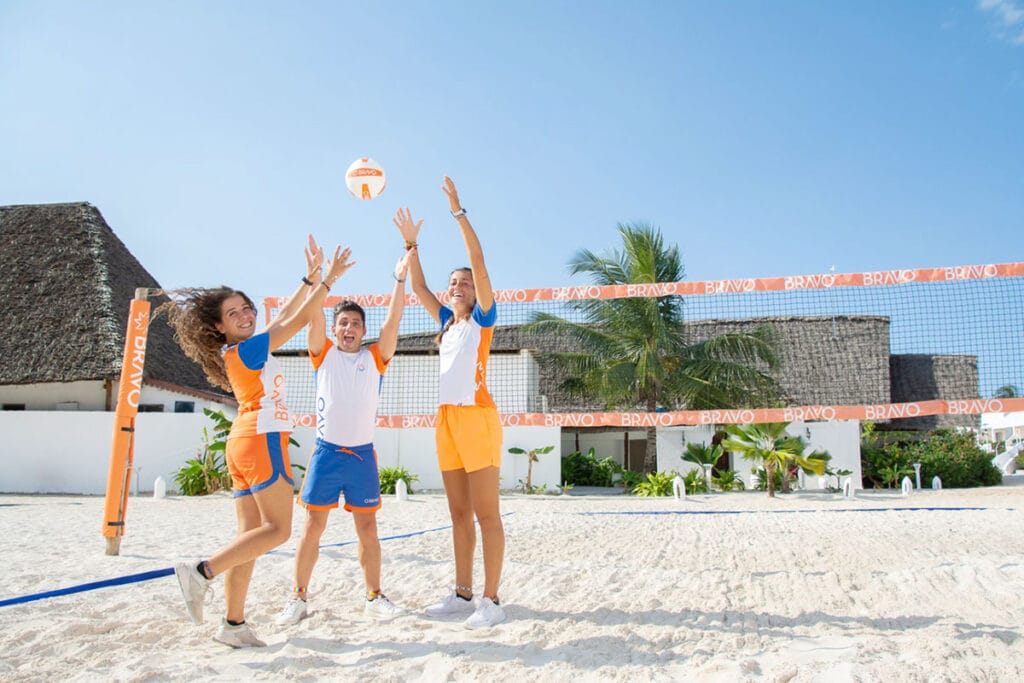 Un gruppo di persone gioca a pallavolo sulla spiaggia.