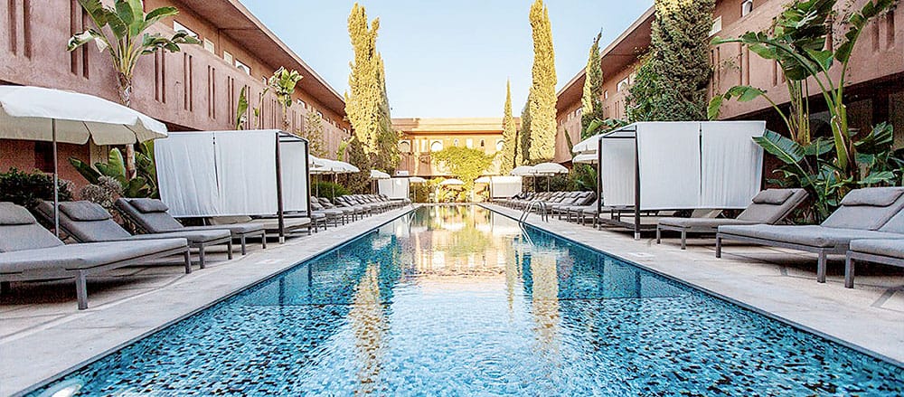 Una piscina con lettini e ombrelloni nel cortile dell'Imperiale.