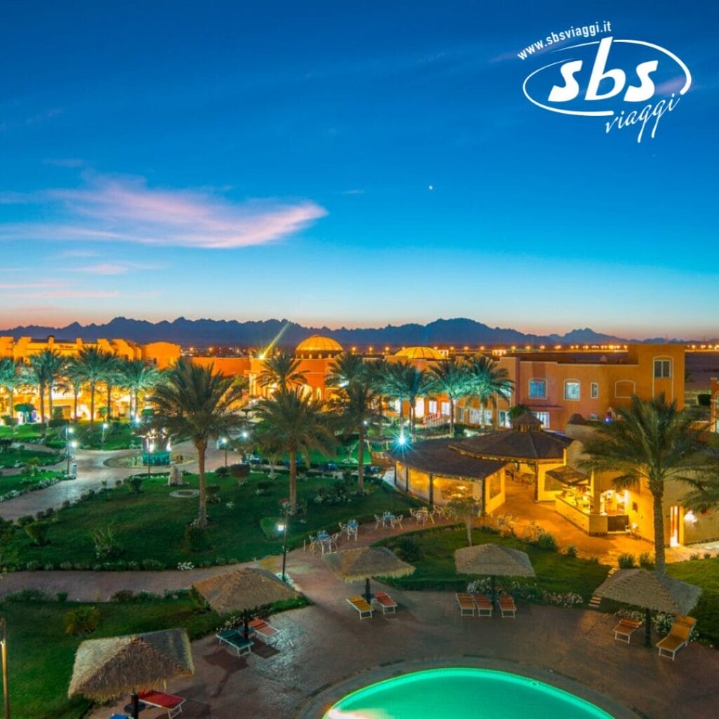 Un resort al tramonto con sentieri illuminati, vegetazione e palme, con una piscina in primo piano e montagne sullo sfondo evoca l'atmosfera serena di Soma Bay. Il logo 