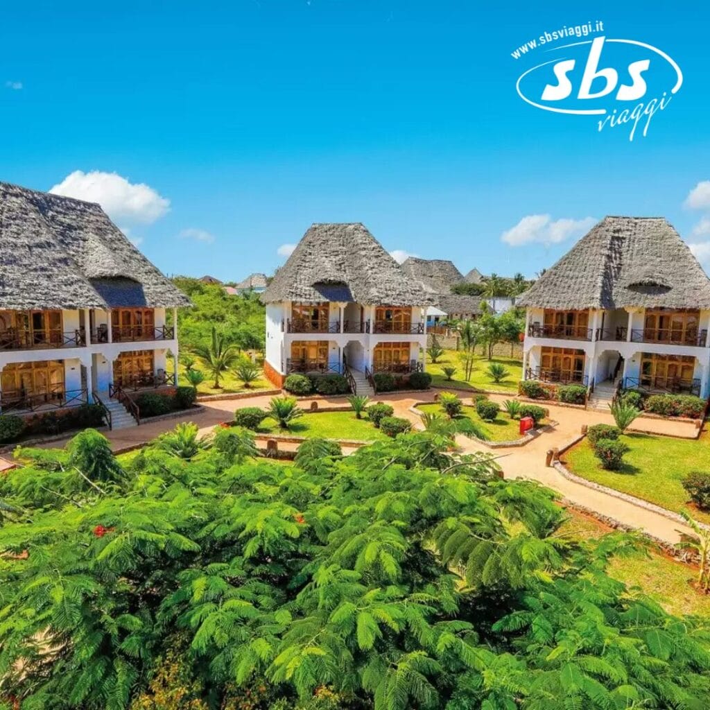 Ville con tetto di paglia circondate da una vegetazione lussureggiante sotto un cielo azzurro e terso a Sunset Beach, con il logo SBS Viaggi in un angolo.