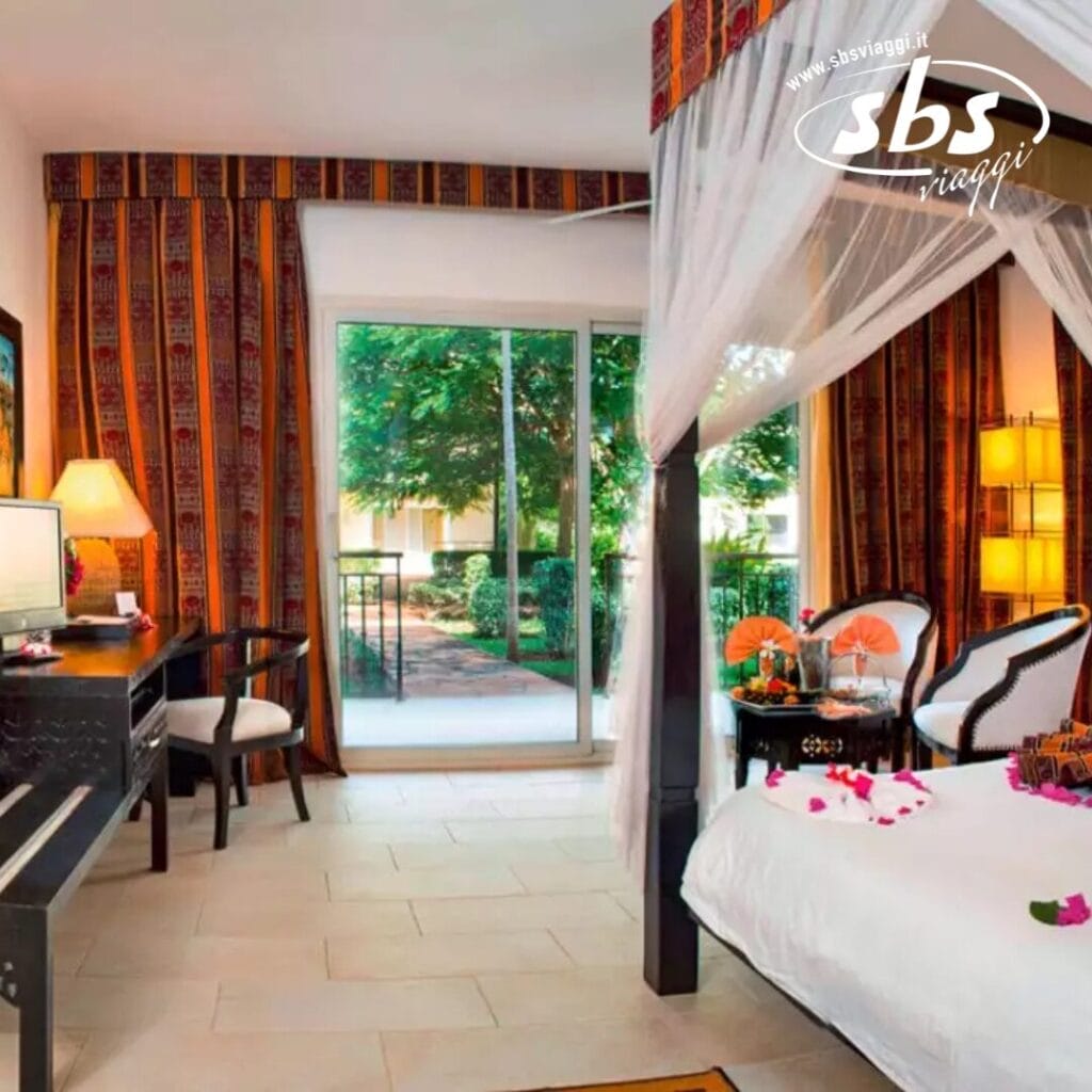 Vivi un soggiorno da sogno nella nostra camera d'albergo dotata di un lussuoso letto a baldacchino e di un'elegante scrivania. Le porte scorrevoli in vetro si aprono per rivelare una vista sul giardino, accentuata da tende a fantasia e una TV a schermo piatto. Abbraccia l'essenza Tui Blue Bahari che infonde comfort ed eleganza in ogni angolo.