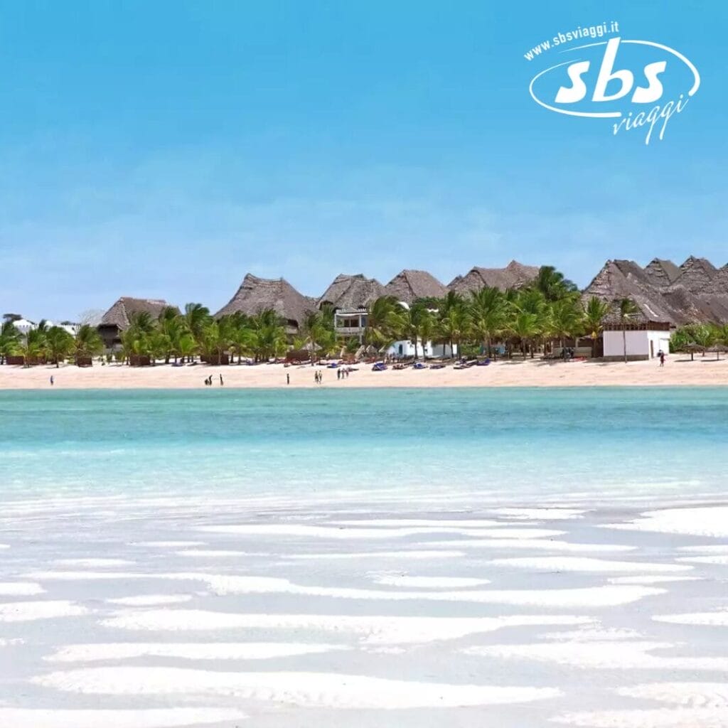 Una spiaggia tropicale con acqua cristallina, palme ondeggianti e edifici con tetti di paglia sullo sfondo, sotto un cielo terso, creano uno scenario così perfetto da poter essere scambiato per una bozza automatica.