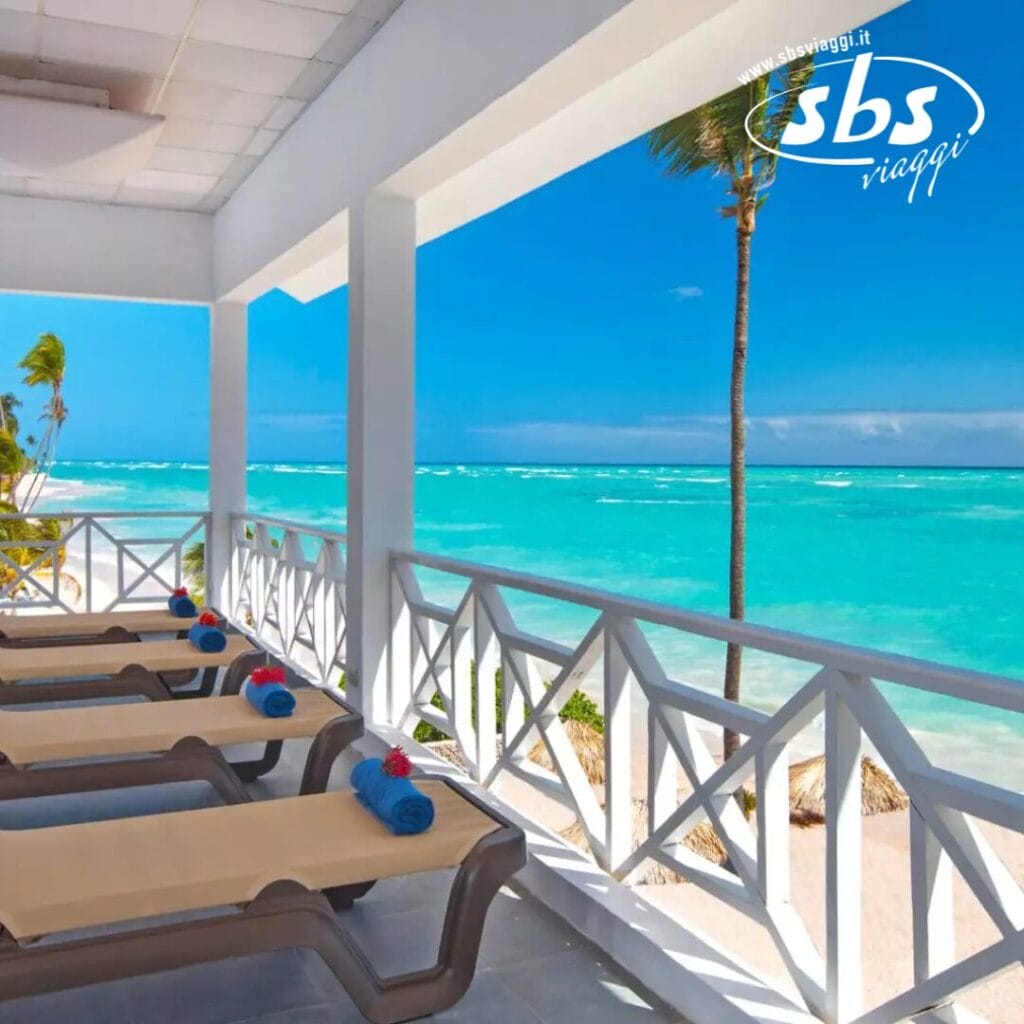 Patio fronte mare al Whala! Bavaro con sedie a sdraio con vista sull'oceano turchese e sulle palme sotto un cielo azzurro e terso.