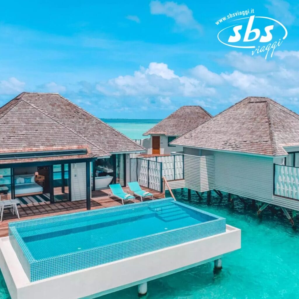 I bungalow sull'acqua con tetti di paglia e piscina privata si affacciano sull'oceano turchese sotto un cielo azzurro e limpido al Nova Maldives sull'isola di Vakarufalhi.
