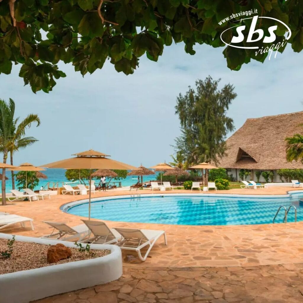 Il Sandies Seaclub offre una splendida area piscina da resort tropicale con lettini e ombrelloni, circondata da alberi rigogliosi e da un affascinante edificio con tetto di paglia. È perfettamente situato accanto a una spiaggia incontaminata con acque turchesi, offrendo una fuga indimenticabile.