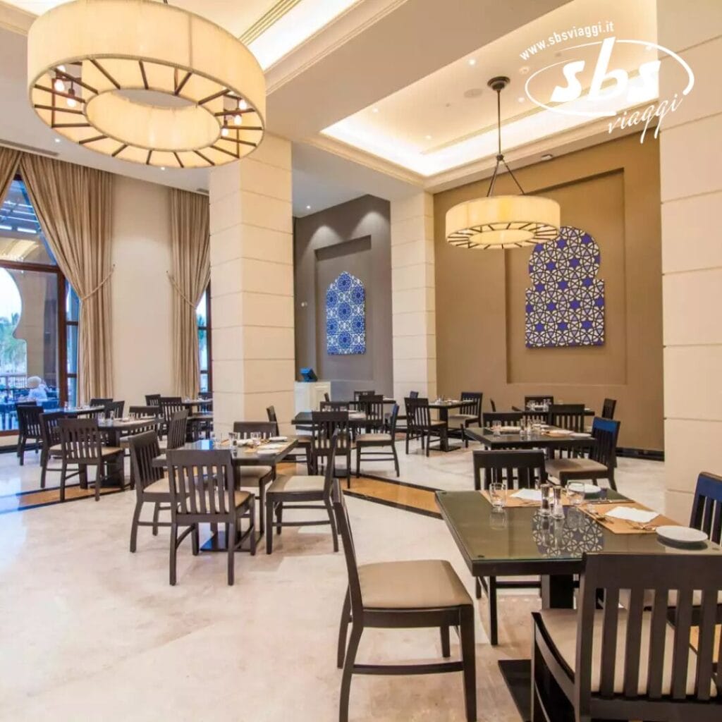 Un ristorante moderno con tavoli e sedie in legno, eleganti lampade e pareti decorative ispirate al fascino costiero del Seaclub.