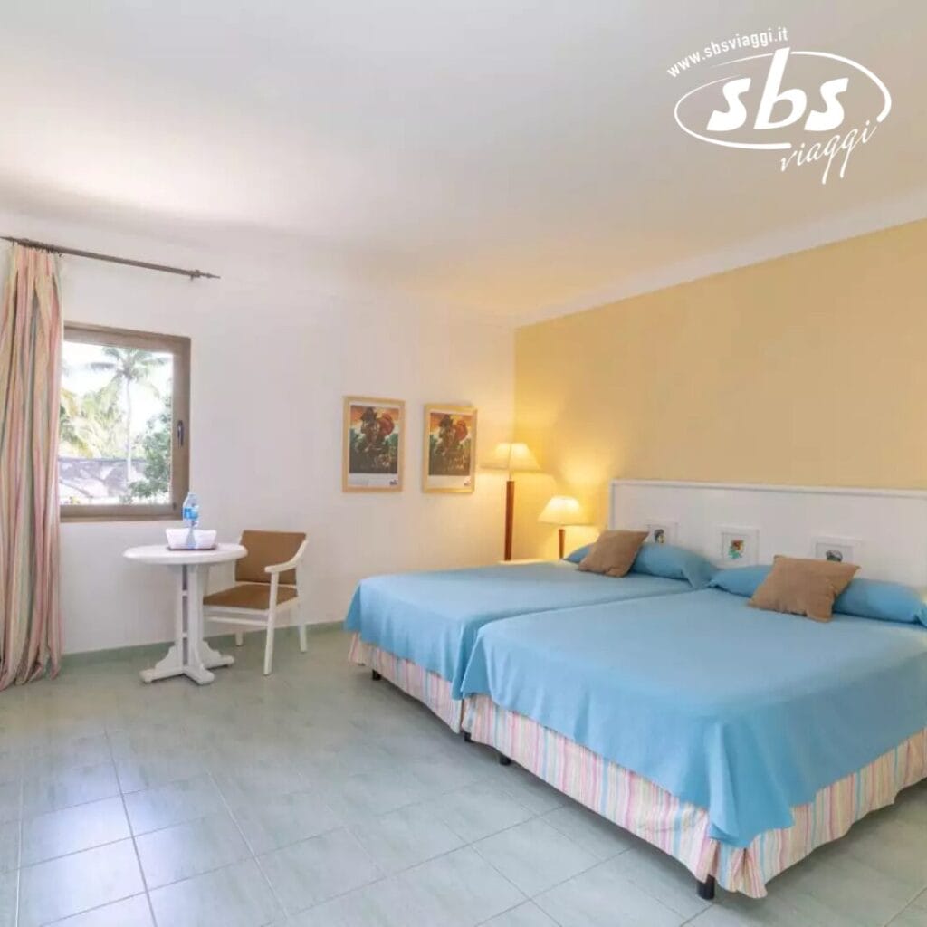 Provate il comfort di questa graziosa camera d'albergo, dotata di due letti singoli e un accogliente tavolo rotondo con sedia. Godetevi la vista dalla finestra mentre i colori tenui leniscono i vostri sensi. L'arredamento di buon gusto include due quadri incorniciati e una lampada, creando un'atmosfera con un tocco di eleganza Bozza automatica.