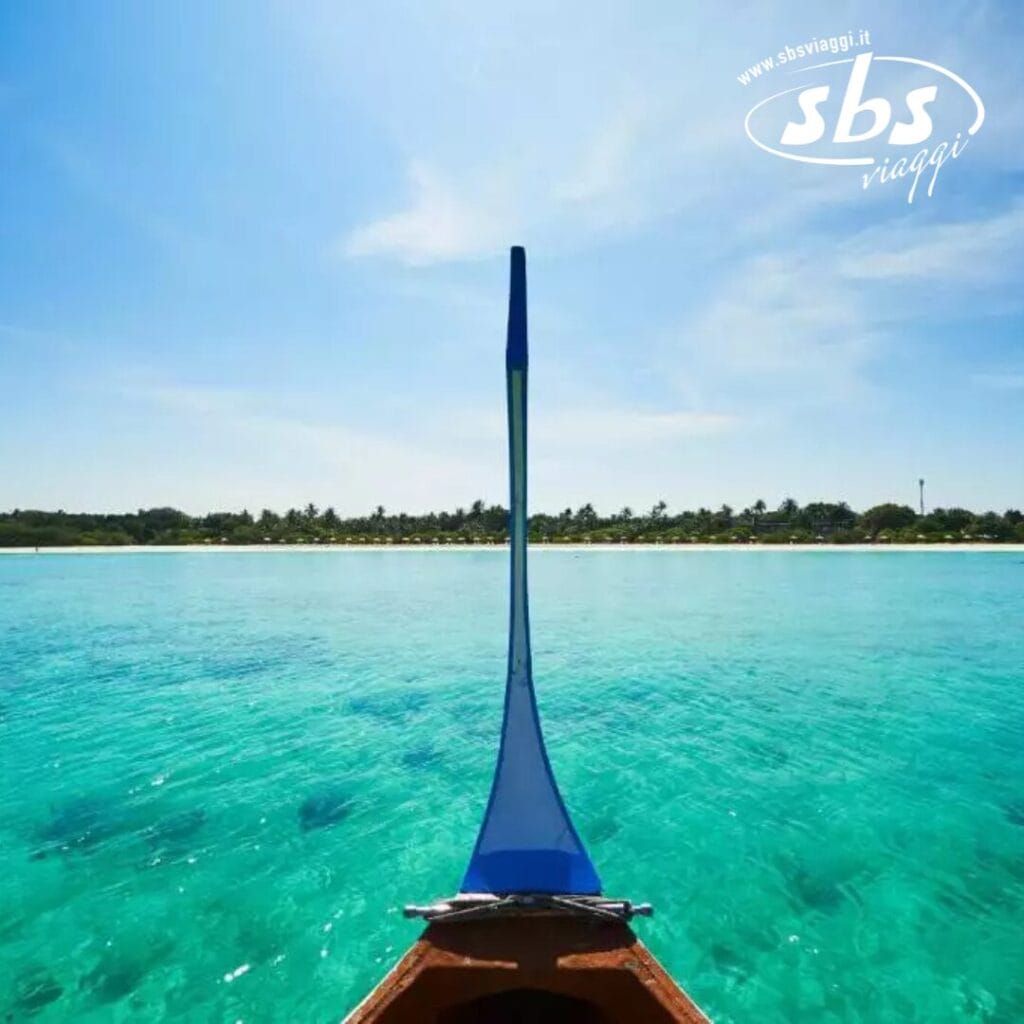 Dal ponte di una barca, ammirate le limpide acque turchesi fino alla costa lontana, dove il Barefoot Eco Hotel si fonde armoniosamente con il vivace paesaggio naturale sotto un limpido cielo azzurro.