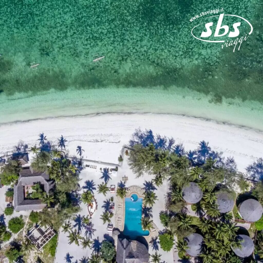 Vista aerea dello Zanzibar Resort con palme, una splendida piscina e acque turchesi e cristalline lungo la costa di Kae Beach.