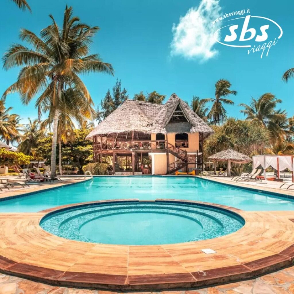 Piscina del Sunny Zanzibar Resort con palme, sedie a sdraio e un edificio con tetto di paglia sullo sfondo. Il fascino caratteristico del Club Coralia è evidente, creando un rifugio tropicale. Il logo SBS Viaggi è nell'angolo in alto a destra.