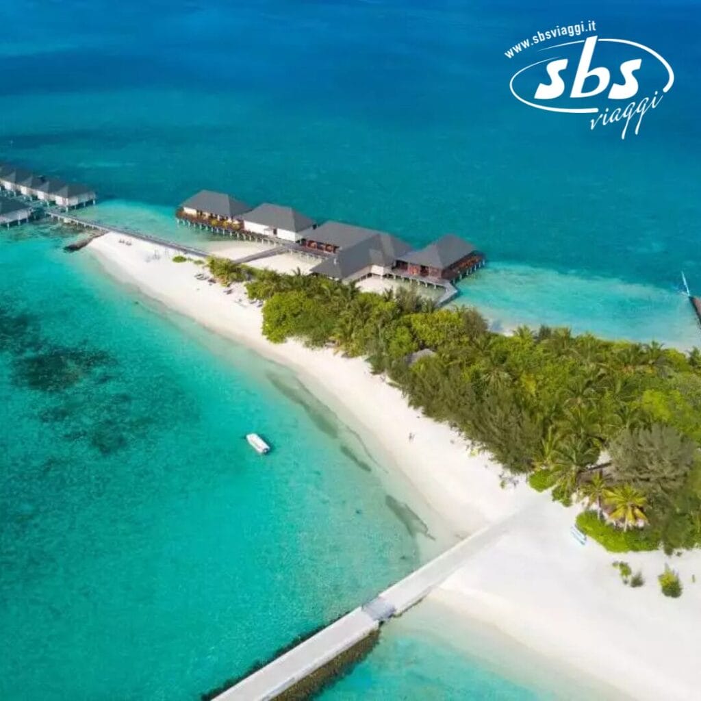 Vista aerea di un'isola con ville affacciate su acque turchesi e una costa sabbiosa che si estende nell'oceano, il tutto circondato da una vegetazione lussureggiante.