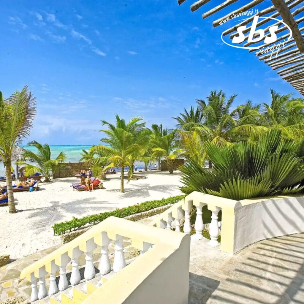 La scena della spiaggia si dispiega con palme che ondeggiano sulla sabbia bianca, dove le persone si rilassano sotto un cielo azzurro e limpido. I gradini in primo piano conducono a questo paradiso. Nell'angolo in alto a destra, il logo