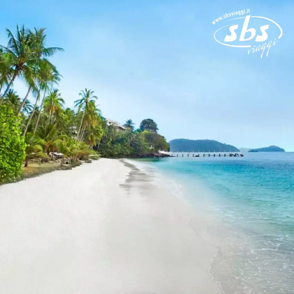 Spiaggia tropicale con sabbia bianca, acqua azzurra e palme sotto un cielo luminoso, che mostra il fascino di un resort sulla spiaggia thailandese. Logo