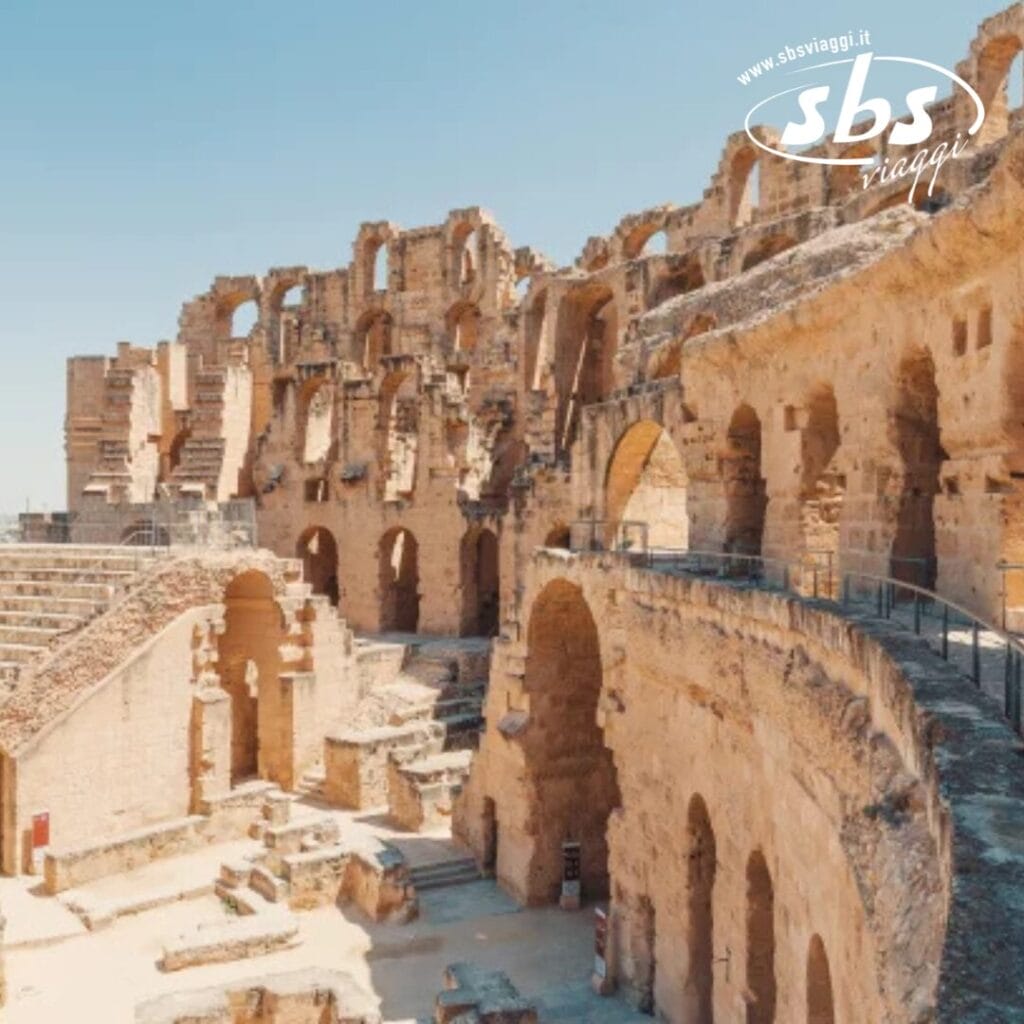 Le rovine di un antico anfiteatro con più archi e gradinate, osservate sotto un cielo limpido, riflettono una bozza automatica architettonica dei tempi passati.