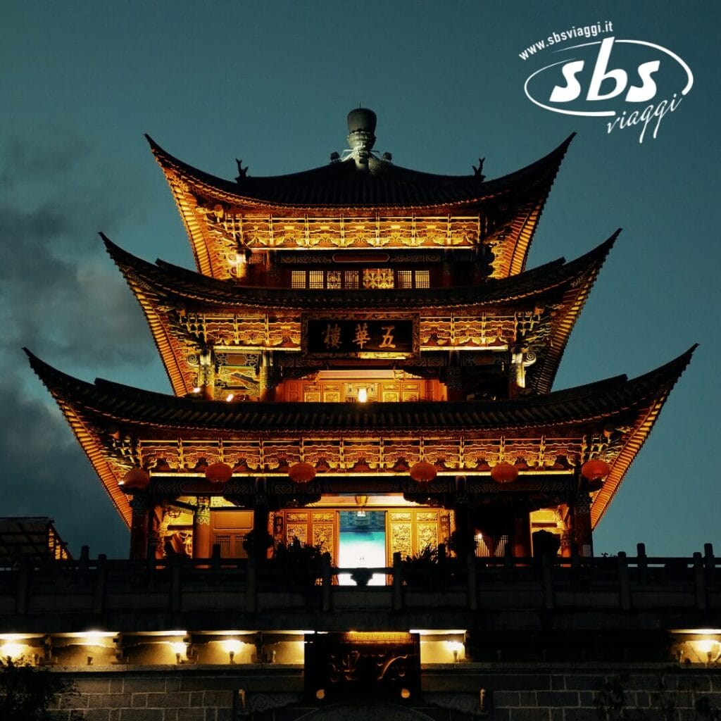 Pagoda tradizionale illuminata di notte con un sublime e intricato design del tetto, lanterne e base in pietra, con il logo