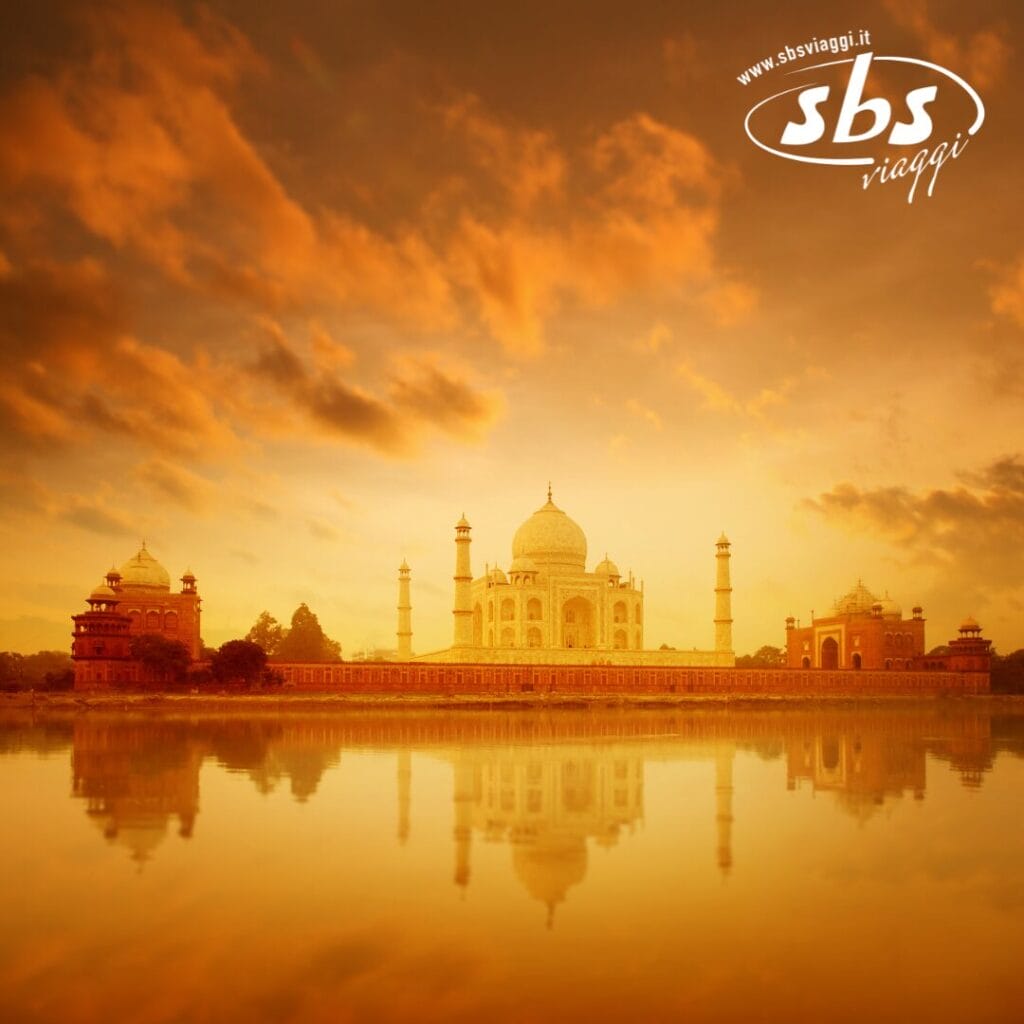 Una vista mozzafiato del Taj Mahal all'alba, il suo riflesso che luccica nel fiume Yamuna sotto un caldo cielo arancione con nuvole sparse. La scena pacifica è sottilmente esaltata dal logo Bozza automatica nell'angolo in alto a destra.
