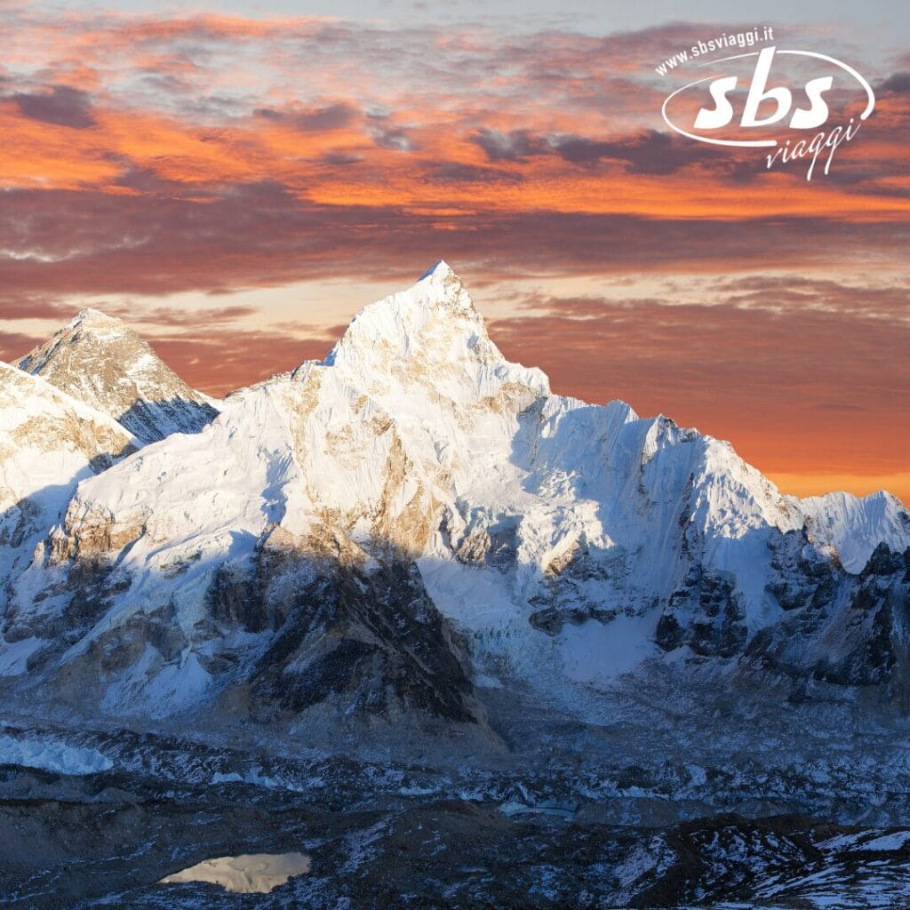 Vette innevate con cielo al tramonto. Logo