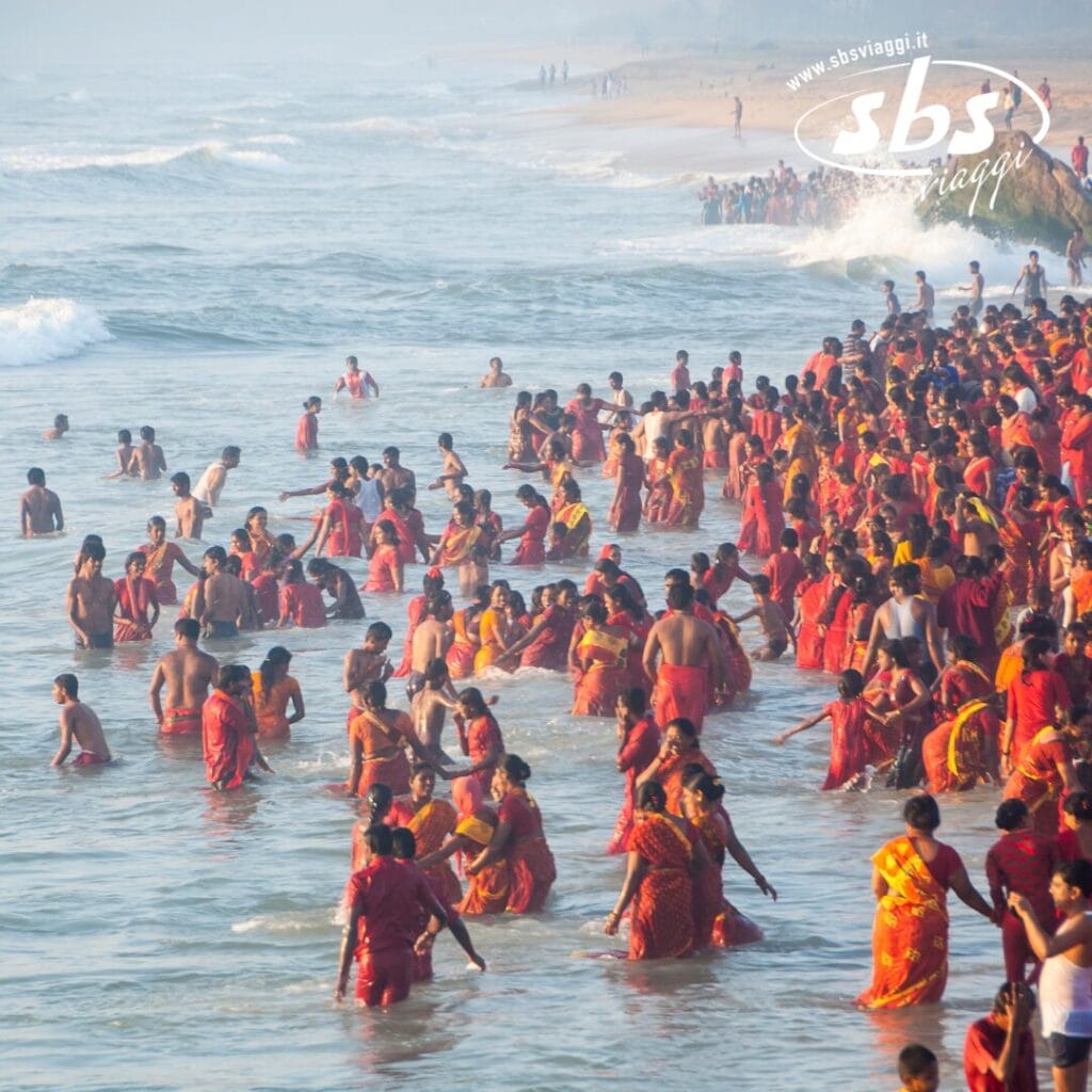 Un folto gruppo di persone in abiti rossi sta in piedi tra le onde dell'oceano vicino alla riva, avvolto da uno sfondo nebbioso. La scena trasmette un fascino misterioso, sottolineato dal logo prominente della Bozza Automatica in alto.