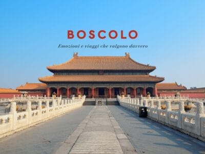 Un tradizionale palazzo cinese con tetti decorati sotto un cielo azzurro; il testo in alto recita "BOSCOLO" in rosso, evocando il sublime incanto di un'esperienza Tour Cina.