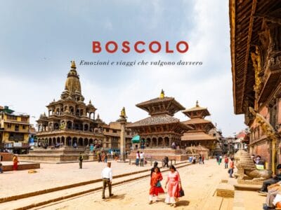 Persone che passeggiano in una piazza storica con antichi templi e il testo “Boscolo: Emozioni e viaggi che valgono davvero.”.