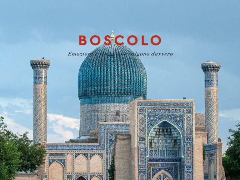 Moschea con piastrelle blu, grande cupola e due minareti sotto un cielo azzurro, che evoca lo spirito dell'Uzbekistan, con la scritta "BOSCOLO" sovrapposta.