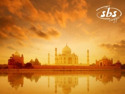 Il Taj Mahal al tramonto, riflesso in un fiume calmo, offre un quadro vibrante con un cielo arancione e nuvole soffici: Bozza automatica cattura perfettamente questo momento sereno.