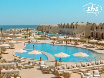 Sunrise Anjum Resort, una lussuosa destinazione a 5 stelle, dispone di due grandi piscine circondate da lettini prendisole e ombrelloni. Mentre il mare luccica sullo sfondo, eleganti strutture edilizie completano la pittoresca cornice.