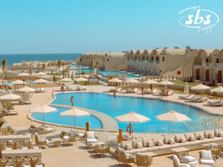 Sunrise Anjum Resort, una lussuosa destinazione a 5 stelle, dispone di due grandi piscine circondate da lettini prendisole e ombrelloni. Mentre il mare luccica sullo sfondo, eleganti strutture edilizie completano la pittoresca cornice.