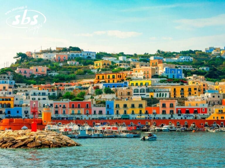 Adagiate sulla suggestiva Isola di Ponza, le case colorate punteggiano la collina lungo uno scintillante lungomare, con graziose barche ormeggiate in primo piano e un cielo limpido sopra di voi, invitandovi a esplorare questo pittoresco gioiello.