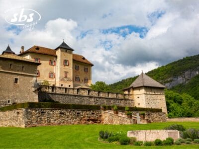 Immerso tra le lussureggianti colline verdi del Trentino Alto Adige, questo storico castello in pietra, decorato con persiane rosse, invita all'esplorazione. I suoi giardini ben curati offrono viste pittoresche sotto un cielo nuvoloso, rendendolo una tappa obbligata in qualsiasi tour dei Castelli.