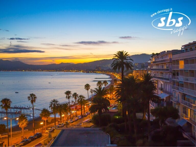Il paesaggio urbano costiero al tramonto, con le strade illuminate, le palme e le montagne sullo sfondo, crea una serena bozza automatica, catturando l'essenza della tranquillità e della bellezza naturale.