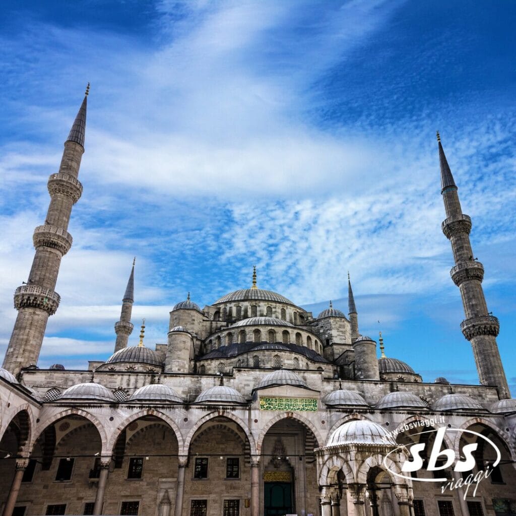 La Moschea Blu di Istanbul, con i suoi sei minareti e le cupole che si stagliano contro un cielo azzurro parzialmente nuvoloso, è una tappa obbligata di ogni tour di Capo Nord prima di dirigersi verso le maestose isole Lofoten.