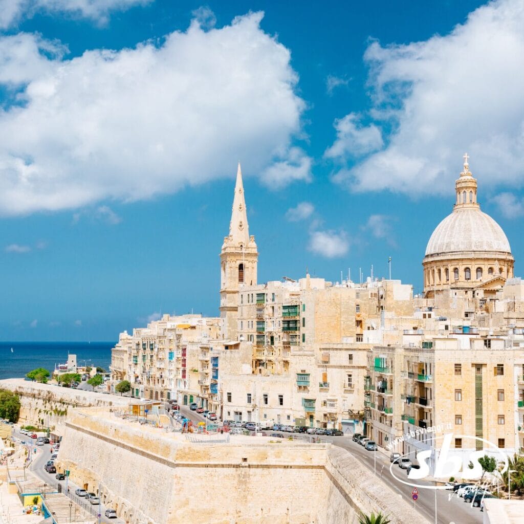 Lo skyline di una città storica con la sua chiesa a cupola e i suoi edifici con guglie, strutture color sabbia che si estendono sotto un cielo azzurro terso con nuvole sparse: perfetto per una crociera MSC o magari per un tranquillo trekking urbano.