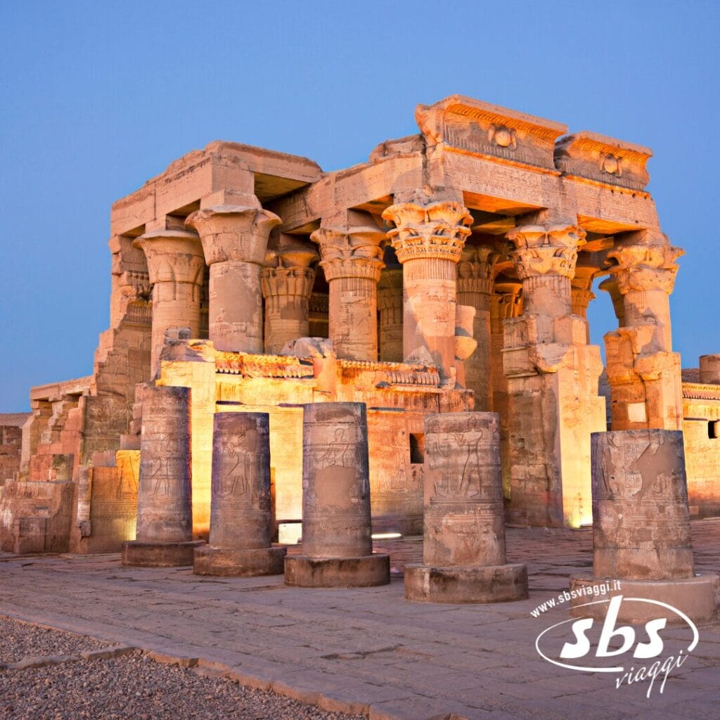 Le antiche colonne in pietra e le rovine del Tempio di Kom Ombo in Egitto, illuminate al tramonto con un cielo limpido sullo sfondo, si ergono come simboli senza tempo dell'Antico Egitto lungo le rive del Nilo.
