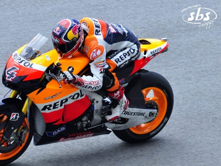 Un motociclista in tenuta Repsol Honda affronta una curva della pista durante un emozionante evento MotoGP.