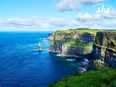 Le scogliere di Moher, situate lungo l'Oceano Atlantico in Irlanda, con ripide scogliere verdi, mare azzurro e cielo parzialmente nuvoloso, sono una meta turistica privilegiata sotto il mutevole Cieli d'Irlanda.