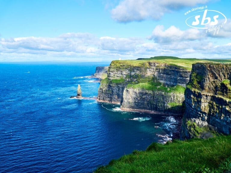 Le scogliere di Moher, situate lungo l'Oceano Atlantico in Irlanda, con ripide scogliere verdi, mare azzurro e cielo parzialmente nuvoloso, sono una meta turistica privilegiata sotto il mutevole Cieli d'Irlanda.