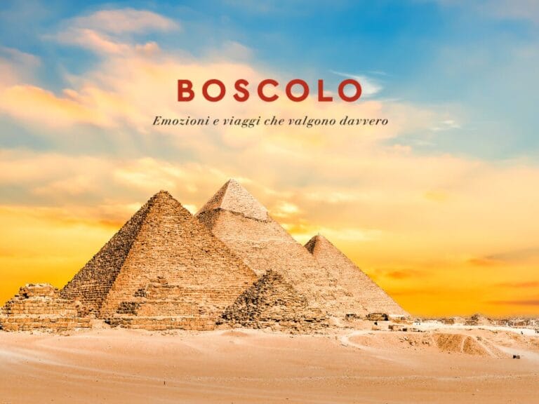 Tre piramidi nel deserto al tramonto, evocanti l'Antico Egitto, con il testo "Boscolo Emozioni e viaggi che valgono davvero.