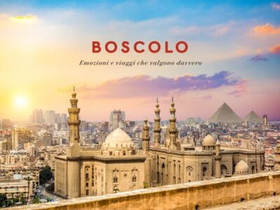 Skyline del Cairo al tramonto con moschee, le Piramidi di Giza e il Nilo sullo sfondo. Testo: "BOSCOLO".