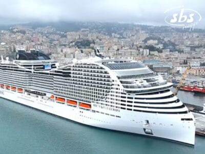 La grande nave da crociera bianca MSC, attraccata nel porto cittadino, è circondata da edifici, mentre le colline offrono uno sfondo mozzafiato, ideale per un'avventura di trekking urbano.