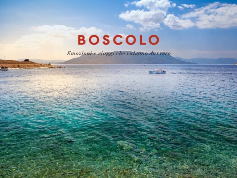 Un mare azzurro e limpido con una barca in lontananza, montagne e la scritta "BOSCOLO" sopra uno slogan italiano nel cielo: uno scenario invitante che ricorda un tour attraverso le Isole Saroniche in un'avventura nella Grecia Classica.