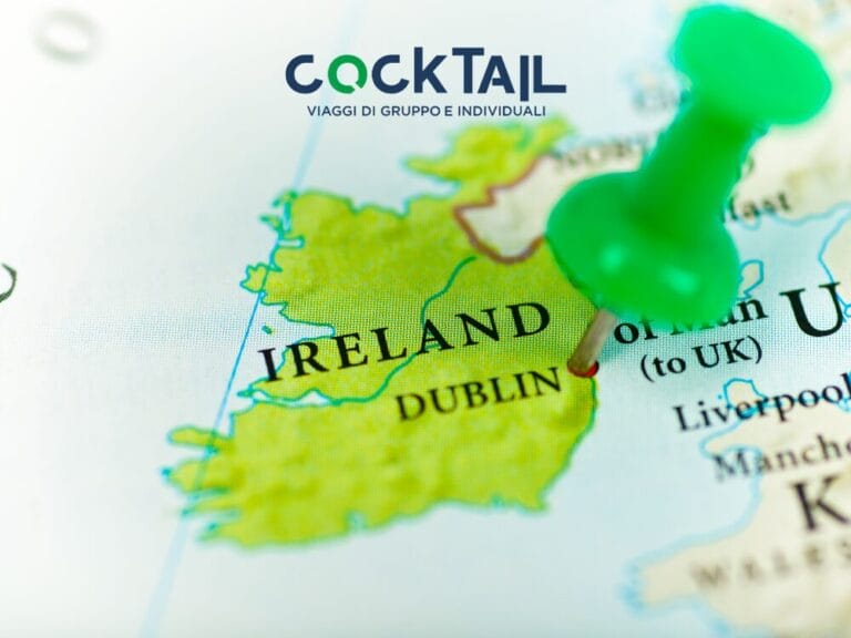 Una puntina verde segna Dublino, Irlanda, su una mappa con sopra il testo di viaggio "COCKTAIL" e un accenno alla ricetta di un cocktail irlandese.