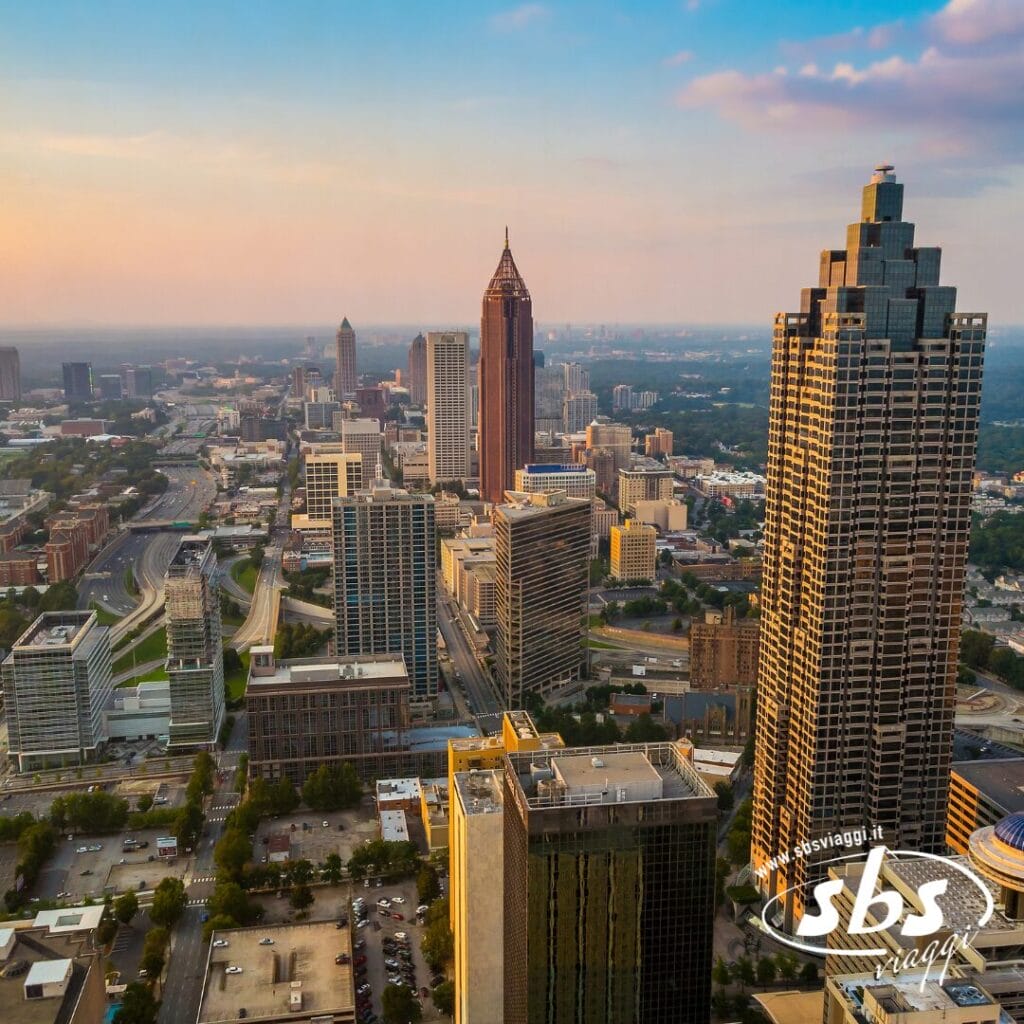 La vista aerea del centro di Atlanta, in Georgia, con i suoi alti edifici per uffici, le strade cittadine e un cielo parzialmente nuvoloso al tramonto, crea uno scenario vivace che ricorda i paesaggi urbani dell'Armenia.