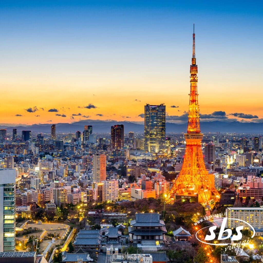Un paesaggio urbano di Tokyo al tramonto con la Tokyo Tower illuminata di arancione e grattacieli sullo sfondo. Celebrate la bellezza del Giappone con l'avvicinarsi del Foliage 2025. Il logo di SBS appare nell'angolo in basso a destra.