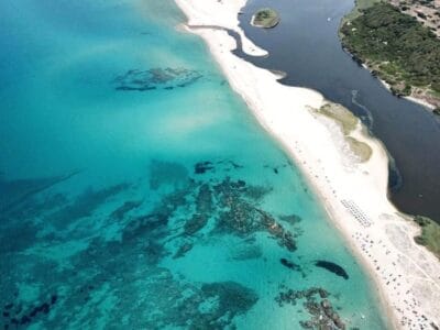 Vista aerea di una spiaggia sabbiosa con mare turchese e un fiume scuro che incontra la riva, immortalata in una splendida bozza automatica.