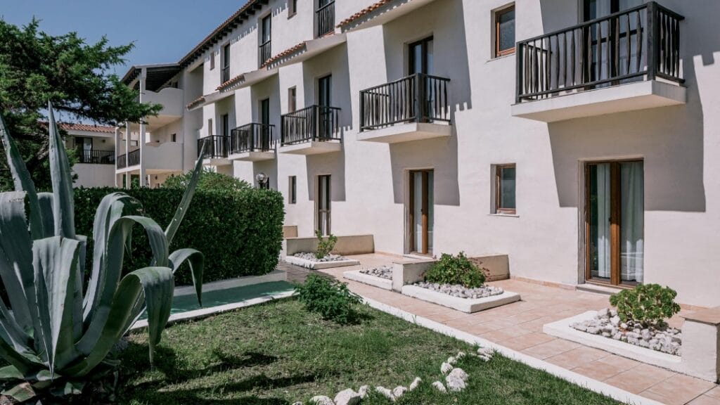 Un edificio moderno con piccoli balconi e porte-finestre, circondato dal verde e dalle aiuole: una vera e propria bomba automatica della vita urbana contemporanea.