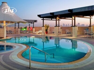Piscina sul tetto con sedie a sdraio e skyline della città sullo sfondo al tramonto: un luogo ideale per rilassarsi al di sopra del trambusto cittadino o per godersi un momento di Bozza automatica.